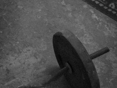 Selection of minimalist gym gear and weights on floor.