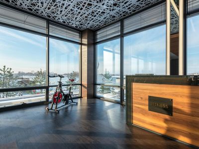 Sunny fitness studio with large windows and clean walls.